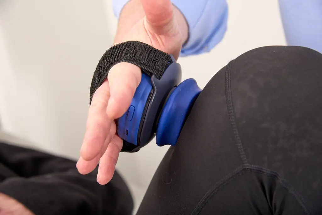 Podiatrist performing manual strength and muscle-testing on a patient's lower limb
